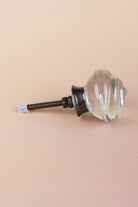Side view of the clear rose glass knob showing the antique brass finish base, the threaded fixing bolt and two nuts