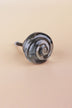 Smokey Grey small rose glass cabinet knob with a swirl curling into the centre, on an antique brass finish base