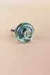 Teal small rose glass cabinet knob, a cool blue-green, with a swirl curling into the centre, on an antique brass finish base