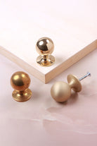 Round cabinet knob in polished, aged and satin brass, second view