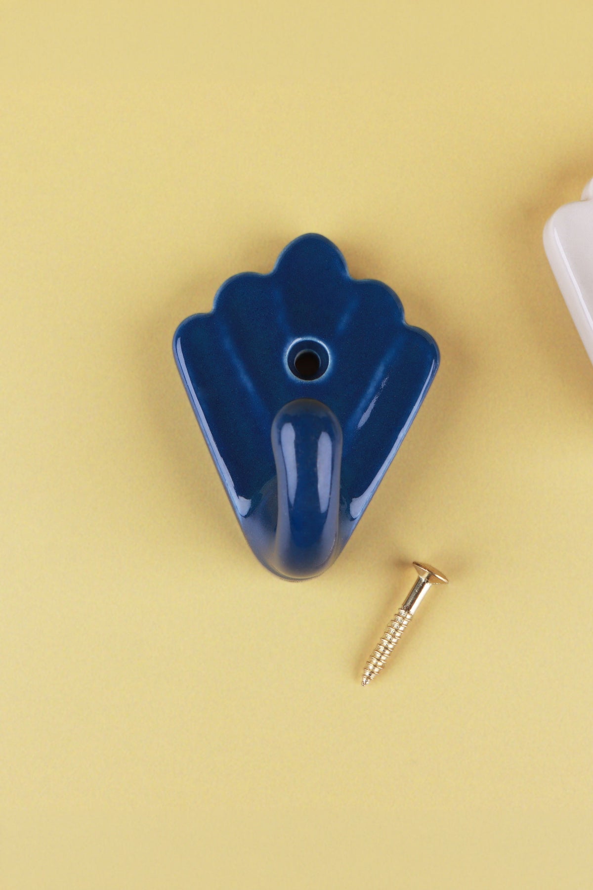 Cobalt blue scallop shell ceramic wall hook, a deep glossy blue, with its brass screw