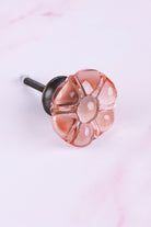 Blush Pink six-petal flower glass cabinet knob, a soft peachy pink, on an antique brass finish base