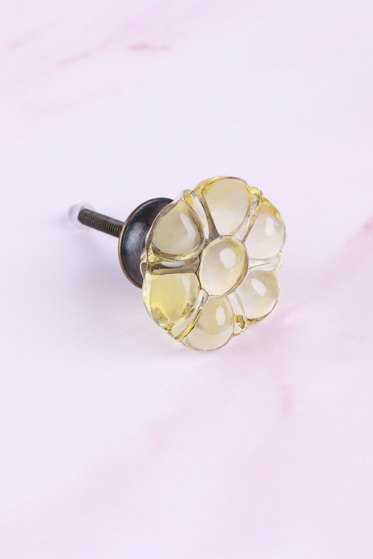 Ivory six-petal flower glass cabinet knob, a pale champagne-yellow tint, on an antique brass finish base