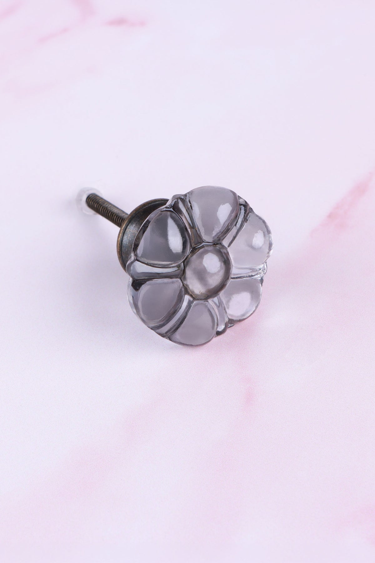 Smokey Grey six-petal flower glass cabinet knob, a cool smoked grey, on an antique brass finish base