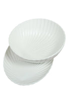 The shell bowl resting on the oval shell dish, on a white background