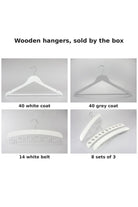 Four boxes of wooden hangers sold by the box: white coat, grey coat, white belt hangers and sets of three accessory hangers