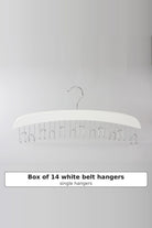 White wooden belt hanger with a row of metal hooks underneath, sold as a box of 14