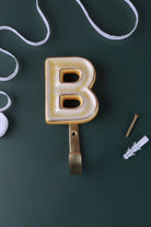 Yellow ceramic letter hook B with a gold rim
