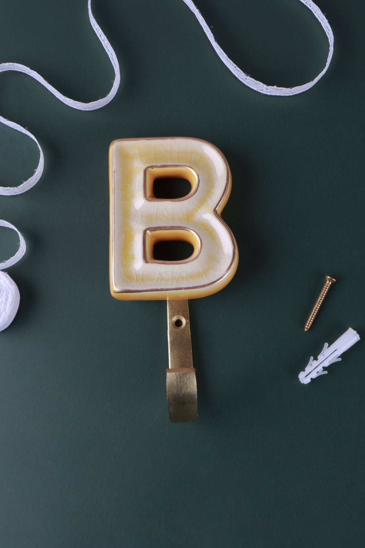 Yellow ceramic letter hook B with a gold rim