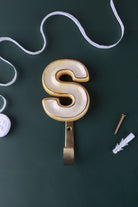 Yellow ceramic letter hook S with a gold rim