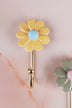Yellow ceramic daisy wall hook with a light blue centre on a gold-tone metal hook