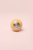 White Striped Hand-Painted Ceramic Cabinet Knob in Pink and Yellow — close-up view, G Decor